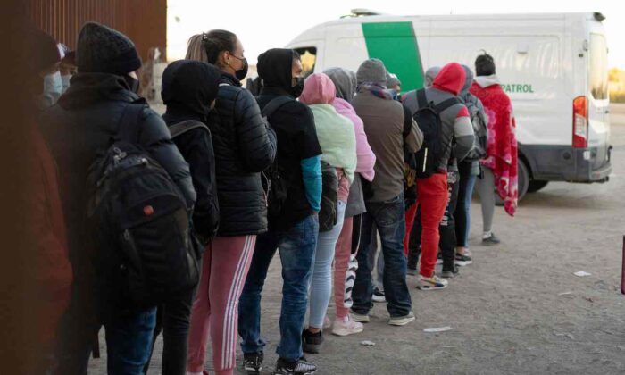 Những người ngoại quốc bất hợp pháp muốn xin tị nạn xếp hàng để được các nhân viên của Cục Hải quan và Biên phòng Hoa Kỳ giải quyết tại một khu vực để trống dọc theo hàng rào biên giới Hoa Kỳ-Mexico gần San Luis, Arizona, hôm 26/12/2022. (Ảnh: Rebecca Noble/AFP qua Getty Images)