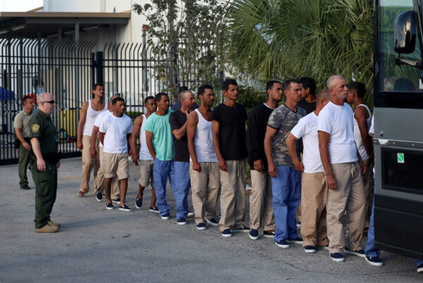 Những người nhập cư bất hợp pháp từ Cuba xếp hàng lên một chiếc xe buýt đưa họ đến trạm kiểm soát của Cục Hải quan và Biên phòng Hoa Kỳ khi họ đang được tiếp nhận ở Marathon, Florida, hôm 05/01/2023. (Ảnh: Joe Raedle/Getty Images)