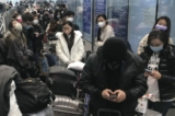 Du khách nội địa chờ đợi hàng giờ để lên xe buýt rời khỏi các khách sạn và cơ sở cách ly từ Phi trường Bạch Vân Quảng Châu ở tỉnh Quảng Đông, miền nam Trung Quốc hôm 25/12/2022. (Ảnh: The Canadian Press/AP, Emily Wang Fujiyama)