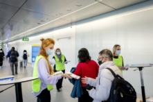 Một nhân viên của Sở Y tế Thành phố Hà Lan (GGD) phát bộ dụng cụ tự xét nghiệm COVID-19 miễn phí cho khách du lịch đến từ Trung Quốc, tại Phi trường Schiphol, Hà Lan, hôm 04/01/2023. (Ảnh: Robin van Lonkhuijsen/ANP/AFP qua Getty Images)