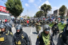 Các thành viên của cảnh sát hộ tống những người ủng hộ cựu Tổng thống Pedro Castillo trong khi họ diễu hành đến trung tâm thành phố Arequipa, Peru, yêu cầu đóng cửa Quốc hội và trả tự do cho ông Castillo, hôm 14/12/2022. (Ảnh: Diego Ramos/AFP qua Getty Images)