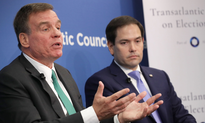 TNS Mark Warner (Dân Chủ-Virginia) (trái) và TNS Marco Rubio (Cộng Hòa-Florida), cả hai đều là thành viên của Ủy ban Tình báo Thượng viện, tham gia một cuộc thảo luận tại Hội đồng Đại Tây Dương ở Hoa Thịnh Đốn vào ngày 16/07/2018. (Ảnh: Chip Somodevilla /Getty Images)