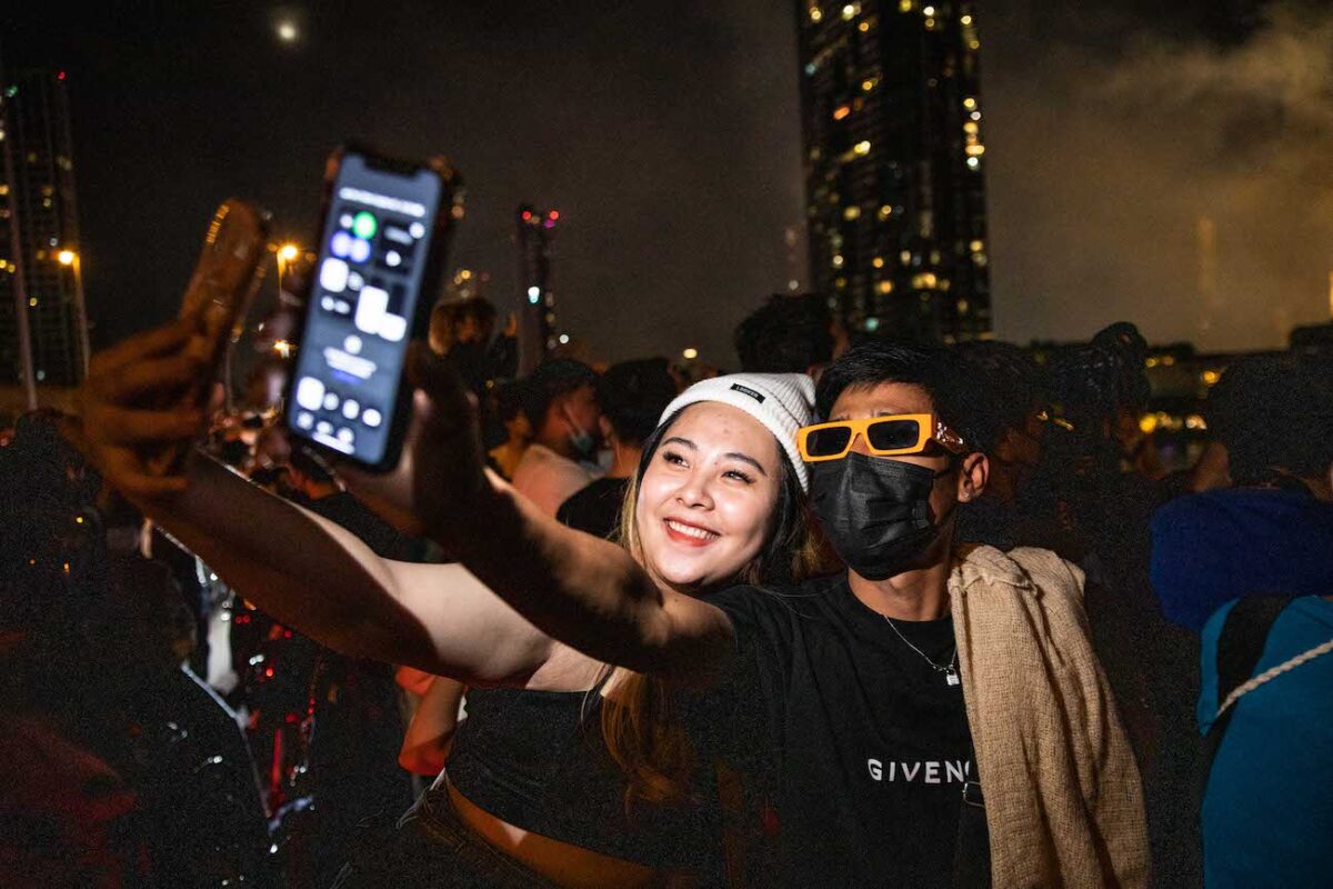 Mọi người chụp ảnh selfie trong màn bắn pháo hoa vào đêm giao thừa từ cầu King Taksin ở Bangkok, Thái Lan, hôm 01/01/2023. (Ảnh: Lauren DeCicca/Getty Images)