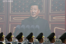 Các binh sĩ Quân Giải phóng Nhân dân đứng trước một màn hình lớn khi lãnh đạo Trung Quốc Tập Cận Bình trình bày tại cuộc duyệt binh kỷ niệm 70 năm thành lập chính quyền ở Bắc Kinh vào ngày 01/10/2019. (Ảnh: Jason Lee/Reuters)