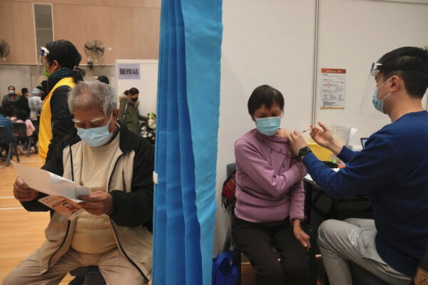 Một phụ nữ lớn tuổi nhận một liều vaccine Sinovac COVID-19 của Trung Quốc tại một trung tâm chích ngừa cộng đồng ở Hồng Kông, hôm 25/02/2022. (Ảnh: Kin Cheung/AP Photo)
