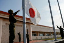 Các thành viên của Lực lượng Phòng vệ Mặt đất Nhật Bản (JGSDF) hạ quốc kỳ Nhật Bản vào đầu giờ tối, tại doanh trại quân sự Miyako trên đảo Miyako, tỉnh Okinawa, Nhật Bản, hôm 20/04/2022. (Ảnh: Issei Kato/Reuters)