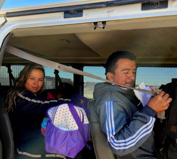 Một gia đình nhập cư bất hợp pháp từ Columbia đợi bên trong một chiếc xe của Lực lượng Tuần tra Biên giới Hoa Kỳ tại bức tường biên giới phía nam ở San Luis, Arizona, hôm 27/1/2023. (Ảnh: Allan Stein/The Epoch Times)