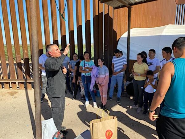 Một linh mục Công Giáo làm lễ cầu nguyện cho một nhóm người di cư bất hợp pháp mới đến tại bức tường biên giới ở San Luis, Arizona. (Ảnh: Đăng dưới sự cho phép của Trung úy Cảnh sát San Luis Marco Santana)