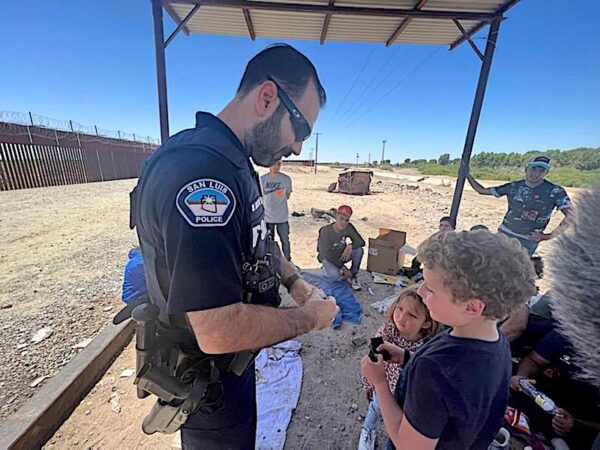 Trung úy Cảnh sát San Luis Marco Santana giúp đỡ một nhóm trẻ em đến từ Colombia tại bức tường biên giới vào cuối tháng 12/2022. (Ảnh: Đăng dưới sự cho phép của Trung úy Cảnh sát San Luis Marco Santana)