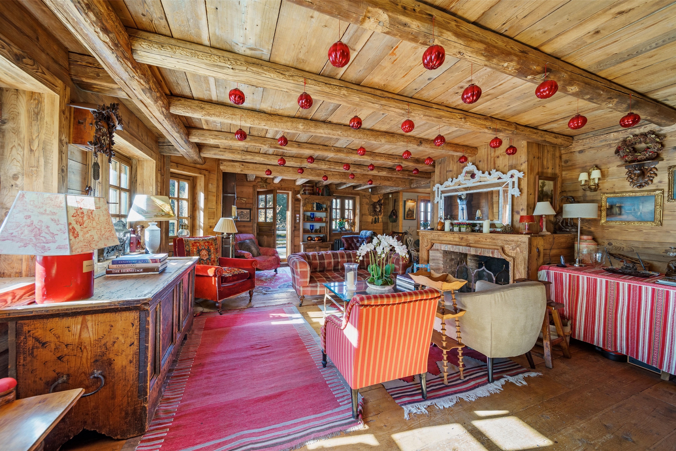 Phòng khách của ngôi nhà gỗ này trông giống như phòng chính của một khu nghỉ mát trượt tuyết đẳng cấp thế giới, với khu vực tiếp khách thoải mái và một lò sưởi cháy bập bùng được tạo điểm nhấn bằng sàn gỗ, tường ốp gỗ và một trần nhà có dầm lộ ra ngoài. (Ảnh: Đăng dưới sự cho phép của Sotheby’s Concierge Auctions)