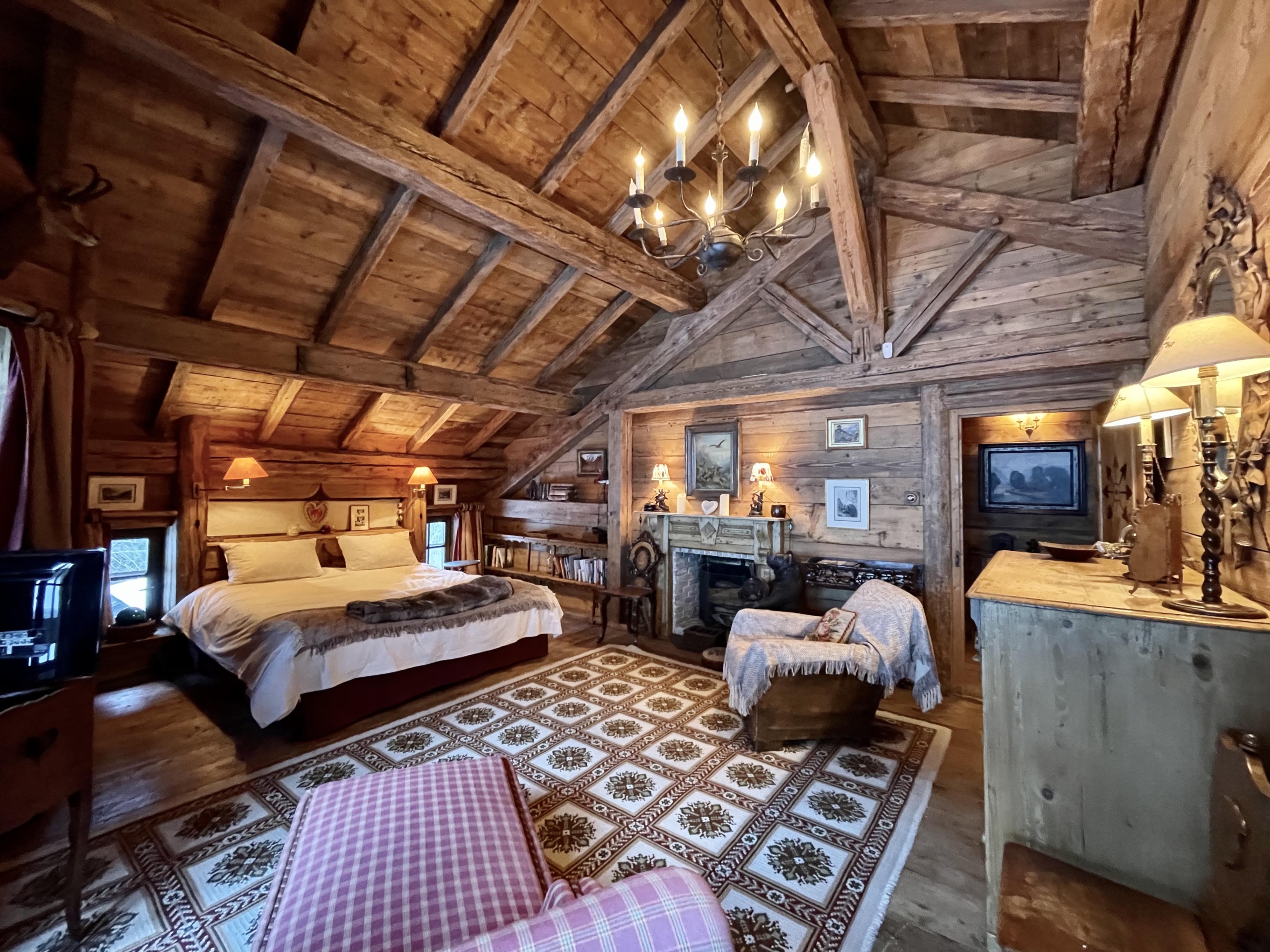 Phòng ngủ chính là một điển hình hoàn hảo cho kiểu phòng sang trọng dành cho những người trượt tuyết, có lò sưởi và đèn chùm lấp lánh, làm nổi bật sàn gỗ, tường và trần nhà có xà lộ ra ngoài. (Ảnh: Đăng dưới sự cho phép của Sotheby’s Concierge Auctions)