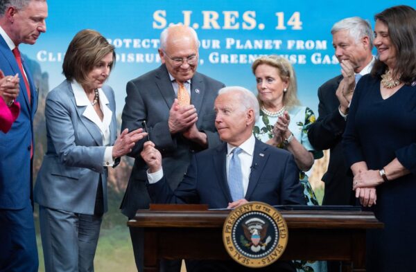 Tổng thống Joe Biden trao một cây bút cho Chủ tịch Hạ viện Nancy Pelosi (thứ 2 từ trái sang), cùng với các nghị sĩ khác của Hạ viện, sau khi ký một dự luật giải quyết vấn đề khí thải nhà kính, tại Tòa nhà Văn phòng Điều hành Eisenhower, ở Hoa Thịnh Đốn, vào ngày 30/06/2021. (Ảnh: Saul Loeb/AFP/Hình ảnh Getty)
