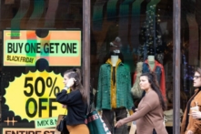 Người mua sắm đi ngang qua các biển hiệu giảm giá ở khu vực mua sắm ngoài trời của Avalon trong Black Friday ở Alpharetta, Giorgia, vào ngày 25/11/2022. (Ảnh: Jessica McGowan/Getty Images)