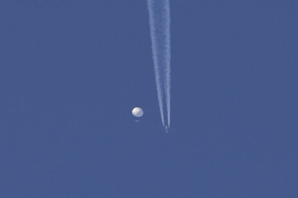 Một khinh khí cầu lớn với một chiếc phi cơ và vệt khói của phi cơ bên dưới đang trôi trên khu vực Kingstown, North Carolina. (Ảnh: Brian Branch qua AP)