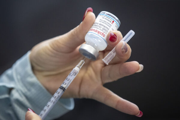 Một nhân viên y tế lấy vaccine Moderna trong một phòng khám chích ngừa vaccine COVID-19 lái xe ngang qua (drive-through) tại Đại học St. Lawrence ở Kingston, Ontario, Canada, hôm 02/01/2022. (Ảnh: The Canadian Press/Lars Hagberg)