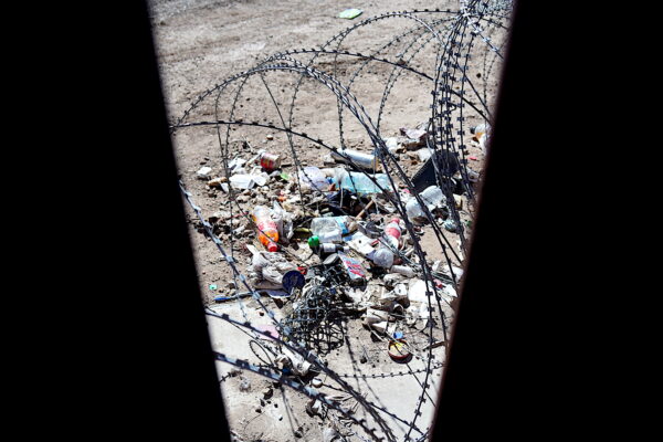 Một đống rác do những người nhập cư bất hợp pháp bỏ lại nằm ở khu vực giữa hai phần của bức tường biên giới trong một khu vực được gọi là “vùng đất không người” ở San Luis, Arizona, hôm 27/01/2023. (Ảnh: Allan Stein/The Epoch Times)