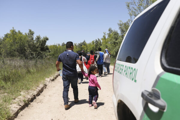Một nhóm người nhập cư bất hợp pháp đi bộ trên đường sau khi từ Mexico băng qua sông Rio Grande. Tiếp tục hành trình này, họ sẽ lên một chiếc xe buýt đến cơ sở quản lý của Lực lượng Tuần tra Biên giới ở McAllen, Texas, vào ngày 18/04/2019. (Ảnh: Charlotte Cuthbertson/The Epoch Times)