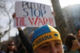 Một người biểu tình đội mũ có hình quốc kỳ Ukraine trong cuộc biểu tình phản đối chiến tranh trước trụ sở Liên minh  u Châu, ở Barcelona, Tây Ban Nha, hôm 24/02/2022. (Ảnh: Nacho Doce/Reuters)