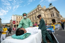 Các học viên Pháp Luân Công tái hiện lại một cảnh thu hoạch nội tạng của các học viên bị cầm tù ở Trung Quốc trong một cuộc biểu tình phản đối việc nhập cảng nội tạng người từ Trung Quốc sang Áo, vào ngày 01/10/2018. (Ảnh: Joe Klamar/AFP/Getty Images)