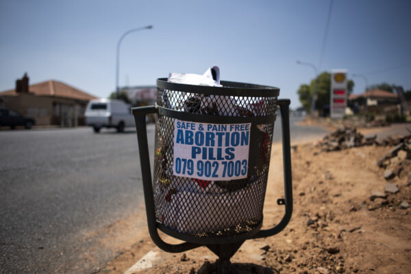 Ảnh tư liệu: Một tấm bích chương quảng cáo bán các loại thuốc phá thai bất hợp pháp được nhìn thấy trên một thùng rác ở Sophiatown, Johannesburg, vào ngày 29/09/2020. (Ảnh: Luca Sola/AFP qua Getty Images)
