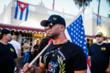 Ông Henry “Enrique” Tarrio, thủ lĩnh đương thời của nhóm Proud Boys, cầm một lá cờ Hoa Kỳ trong một cuộc biểu tình thể hiện sự ủng hộ đối với những người Cuba đang biểu tình chống lại chính phủ của họ, ở Miami, Florida, vào ngày 16/07/2021. (Ảnh: Eva Marie Uzcategui/AFP qua Getty Images)