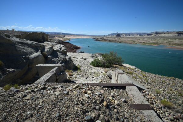 Những tàn tích bị bỏ hoang ở nơi từng có nước tràn vào được nhìn thấy khi mọi người chơi đùa trên sông Colorado ở Hồ Powell, mặc dù mực nước thấp hơn bình thường, ở Vịnh Wahweap ở Page, Arizona, ngày 03/09/2022. (Ảnh: Robyn Beck/AFP qua Getty Images)