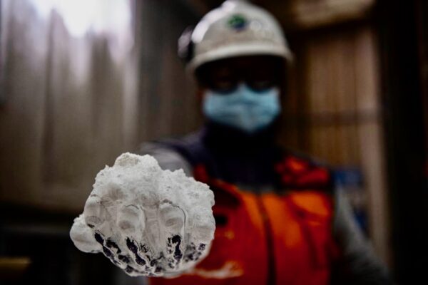 Một công nhân cầm một nắm lithium 99.9% bên trong nhà máy chế biến El Carmen Lithium của công ty Sociedad Quimica Minera ở Antofagasta, Chile, hồi tháng 09/2022. (Ảnh: Martin Bernetti/AFP qua Getty Images)
