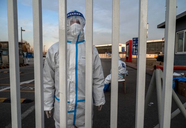 Một nhân viên chống dịch mặc đồ bảo hộ PPE để tránh lây nhiễm COVID-19 khi anh đứng gác tại một cơ sở cách ly của chính quyền ở Bắc Kinh, Trung Quốc, hôm 07/12/2022. (Ảnh: Kevin Frayer/Getty Images)
