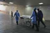 Nhân viên bệnh viện và người thân đẩy một thi thể trên băng ca ra khỏi phòng cấp cứu đông đúc tại một bệnh viện ở Bắc Kinh, Trung Quốc, hôm 02/01/2023. (Ảnh: Getty Images)