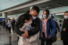 Một người cha ôm con gái của mình vào lòng tại sảnh đến ga quốc tế của Phi trường Thủ đô Bắc Kinh ở Bắc Kinh hôm 08/01/2023. (Ảnh: Kevin Frayer/Getty Images)