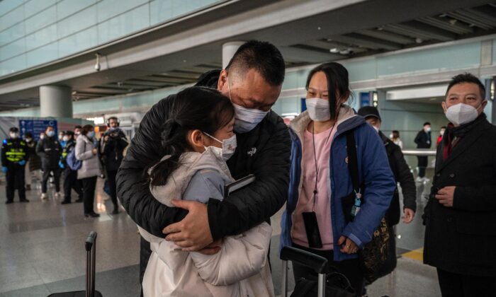 Một người cha ôm con gái của mình vào lòng tại sảnh đến ga quốc tế của Phi trường Thủ đô Bắc Kinh ở Bắc Kinh hôm 08/01/2023. (Ảnh: Kevin Frayer/Getty Images)