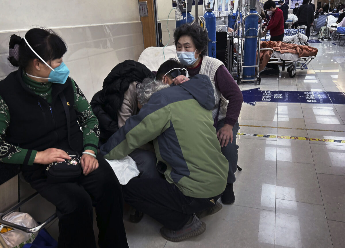 Một bệnh nhân lớn tuổi gục đầu vào vai của người thân trong khi bà được chăm sóc ở ngoài hành lang của phòng cấp cứu đông đúc tại một bệnh viện ở Thượng Hải, Trung Quốc, hôm 14/01/2023. (Ảnh: Kevin Frayer/Getty Images)