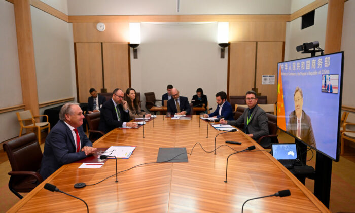 Bộ trưởng Thương mại Úc Don Farrell (trái) nói chuyện với Bộ trưởng Thương mại Trung Quốc Vương Văn Đào trong cuộc họp qua hội nghị truyền hình tại Tòa nhà Quốc hội ở Canberra, Úc, hôm 06/02/2023. (Ảnh: Lukas Coch - Pool/Getty Images)