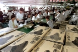 Công nhân tại một nhà máy quốc doanh Trung Quốc sản xuất giày cho một công ty Hoa Kỳ ở Thẩm Dương thuộc tỉnh Liêu Ninh, đông bắc Trung Quốc, hôm 31/05/2000. (Ảnh: Goh Chai Hin/AFP qua Getty Images)