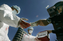 Các học viên Pháp Luân Công mô phỏng cảnh mua bán nội tạng người bất hợp pháp trong một cuộc biểu tình vào ngày 19/04/2006, tại Hoa Thịnh Đốn, nhân chuyến thăm của Chủ tịch Trung Quốc Hồ Cẩm Đào tới Hoa Kỳ. (Ảnh: Jim Watson/AFP qua Getty Images)