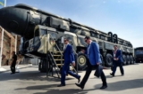 Các chuyên gia quân sự đi ngang qua một hỏa tiễn đạn đạo xuyên lục địa (ICBM) Topol của Nga tại khu vực triển lãm ở Công viên Ái Quốc Kubinka bên ngoài Moscow ngày 22/08/2017. (Ảnh: Alexander Nemenov/AFP/Getty Images)