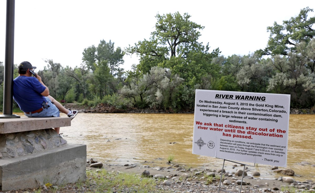 Một biển cảnh báo từ thành phố được hiển thị phía trước sông Animas khi bùn màu cam từ một vụ tràn mỏ ở thượng nguồn chảy qua Công viên Berg ở Farmington, New Mexico, vào ngày 08/08/2015. (Ảnh: Alexa Rogals/The Daily Times qua AP)