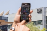 Một phụ nữ Israel sử dụng iPhone của mình trước tòa nhà trụ sở của NSO Group của Israel, ở Herzliya, gần Tel Aviv, Israel, ngày 28/08/2016. (Ảnh: Jack Guez/AFP qua Getty Images)