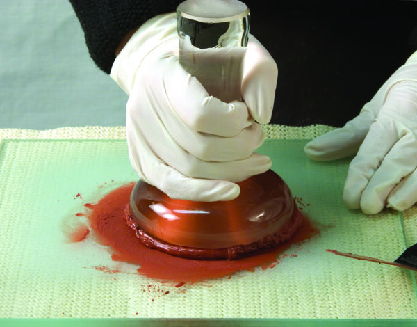 Một nghệ sĩ sử dụng một cái nghiền để mài màu dạng lỏng (pigment paste) cho đến khi hỗn hợp trở nên mịn; các hạt bột màu càng nhỏ, thì quá trình nghiền càng khó hơn. (Ảnh: Đăng dưới sự cho phép của hãng Natural Pigments)