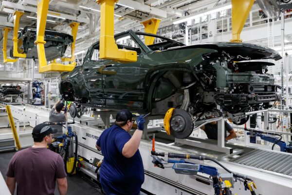 Các nhân viên làm việc trên một dây chuyền lắp ráp tại nhà máy sản xuất xe điện của công ty khởi nghiệp Rivian Automotive ở Normal, Illinois, hôm 11/04/2022. (Ảnh: Kamil Krzaczynski/Reuters)