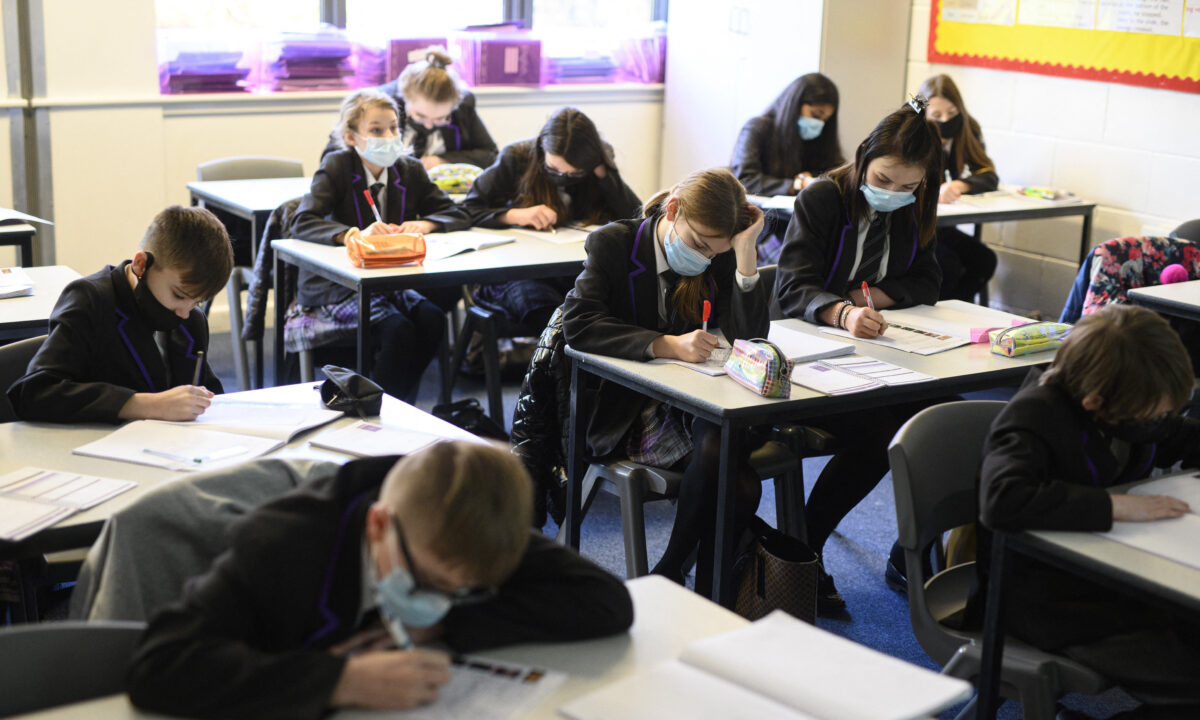Học sinh Lớp 8 đeo khẩu trang hoặc khăn che mặt khi tham gia lớp học tiếng Anh tại Học viện Park Lane ở Halifax, tây bắc nước Anh, vào ngày 04/01/2022. (Ảnh: Oli Scarff/AFP qua Getty Images)