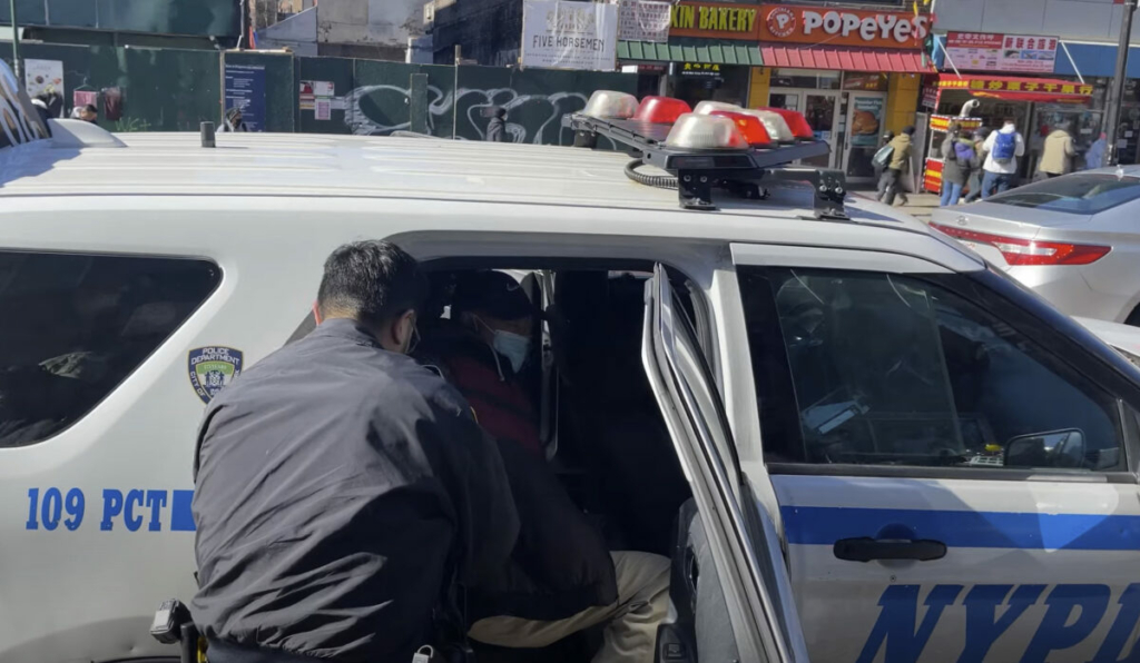 Cảnh sát bắt ông Tề Trung Bình, người phải đối mặt với các cáo buộc tấn công các học viên Pháp Luân Công ở Flushing, New York, hôm 18/02/2023. (Ảnh chụp màn hình qua The Epoch Times)