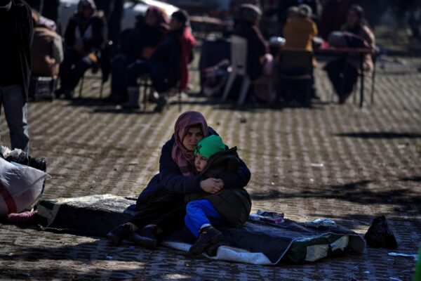 Một người phụ nữ ôm con trai khi họ và những người khác ngồi trong một khu vườn công cộng ở Adiyaman, miền nam Thổ Nhĩ Kỳ, hôm 12/02/2023. (Ảnh: Khalil Hamra/AP Photo)