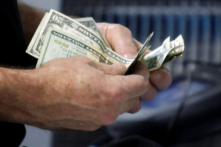 Một khách hàng đếm tiền mặt của mình tại quầy thanh toán khi mua một món hàng tại cửa hàng Best Buy ở Flushing, New York, 27/03/2010. (Ảnh: Reuters/Jessica Rinaldi)