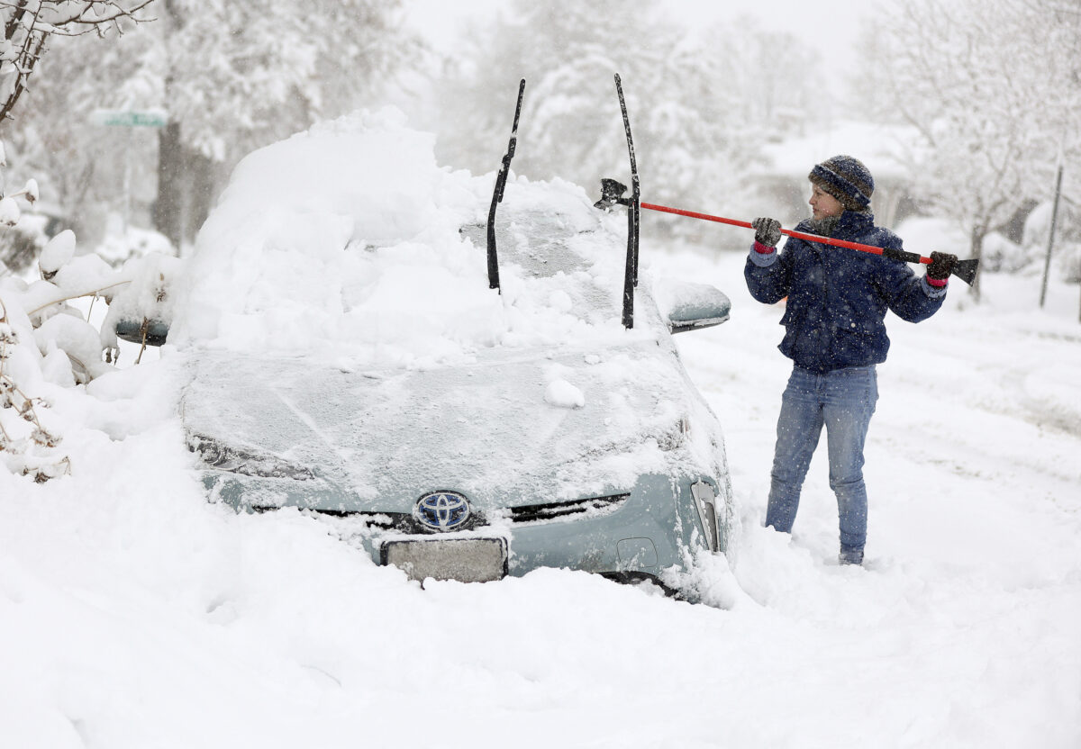 Bà Cathy Morgan-Mace dọn tuyết và băng trên xe hơi của gia đình trong trận bão tuyết ở Thành phố Salt Lake, Utah, hôm 22/02/2023. (Ảnh: Kristin Murphy/The Deseret News qua AP)