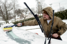 Ông Zach Stimson dọn sạch băng và tuyết cho xe hơi của mình khi chiếc xe này tiếp tục tích tụ tuyết giữa cơn bão mùa đông, ở Lapper, Michigan, hôm 22/02/2023. (Ảnh: Jake May/The Flint Journal qua AP)