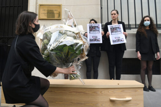 Một người biểu tình đặt hoa tại đại sứ quán Trung Quốc ở Paris để ủng hộ Apple Daily, một tờ báo ủng hộ dân chủ đã bị buộc phải đóng cửa theo Luật An ninh Quốc gia của Hồng Kông, vào ngày 25/06/2021. (Ảnh: Alain Jocard/AFP qua Getty Images)
