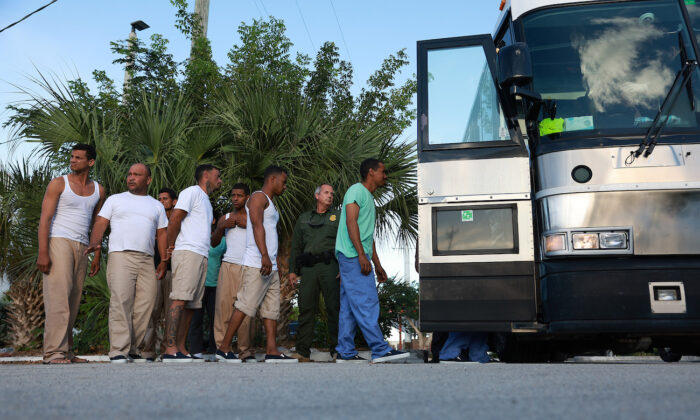 Những người nhập cư bất hợp pháp từ Cuba xếp hàng lên một chiếc xe buýt để được đưa đến trạm Hải quan và Bảo vệ Biên giới Hoa Kỳ khi họ được giải quyết ở Marathon, Florida, hôm 05/01/2023. (Ảnh: Joe Raedle/Getty Images)