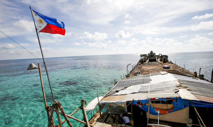 Một lá cờ Philippines bay phấp phới trên con tàu BRP Sierra Madre, một tàu Hải quân Philippines mục nát đã mắc cạn từ năm 1999 và trở thành một căn cứ quân sự của Philippines trên Bãi cạn Thomas thứ Hai (Bãi Cỏ Mây) đang tranh chấp, một phần của Quần đảo Trường Sa, ở Biển Đông ngày 29/03/2014. (Ảnh: Erik De Castro/Reuters)