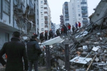 Người dân và các nhóm cứu hộ cố gắng tiếp cận những cư dân bị mắc kẹt bên trong các tòa nhà bị sập ở Adana, Thổ Nhĩ Kỳ, hôm 06/02/2023. (Ảnh: Hãng thông tấn IHA qua AP)